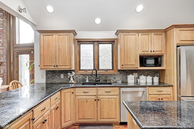 690 N 600 W, Lebanon, IN 46052 - kitchen with stainless steel appliances, decorative backsplash, vaulted ceiling, a sink, and dark stone counters