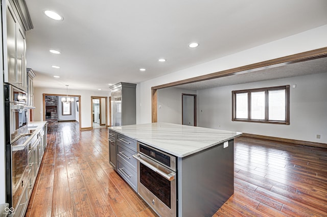 690 N 600 W, Lebanon, IN 46052 - kitchen with recessed lighting, wood-type flooring, light stone countertops, and gray cabinetry
