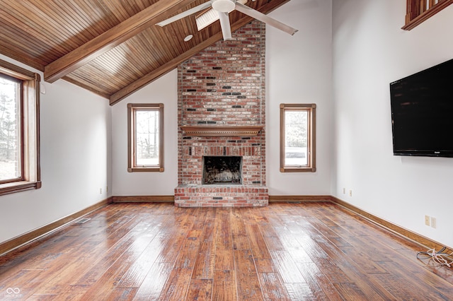 690 N 600 W, Lebanon, IN 46052 - unfurnished living room with lofted ceiling with beams, a brick fireplace, wood-type flooring, and baseboards