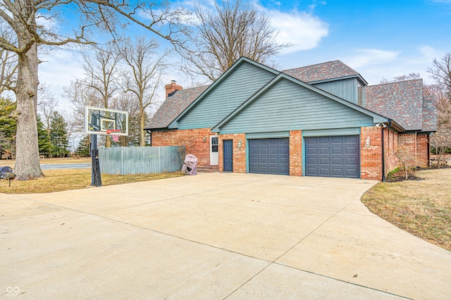 690 N 600 W, Lebanon, IN 46052 - view of property exterior with a garage, concrete driveway, a chimney, fence, and brick siding