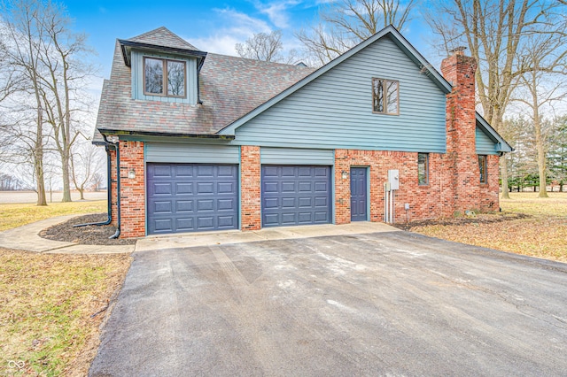 690 N 600 W, Lebanon, IN 46052 - view of front of home with aphalt driveway, brick siding, a chimney, and a garage