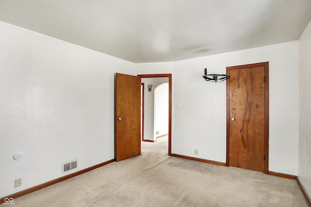 unfurnished room featuring baseboards, visible vents, and light colored carpet