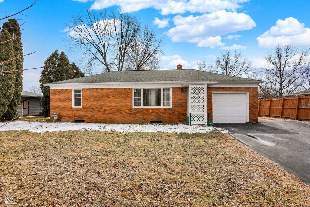 ranch-style home with brick siding, crawl space, an attached garage, and fence