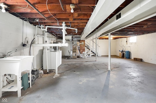 basement with washer and dryer, visible vents, and a sink