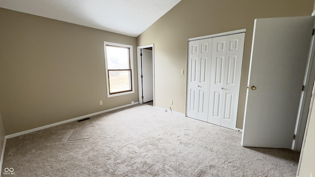 unfurnished bedroom featuring lofted ceiling, light carpet, visible vents, baseboards, and a closet