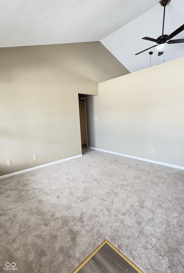 carpeted empty room featuring ceiling fan, high vaulted ceiling, a textured ceiling, and baseboards