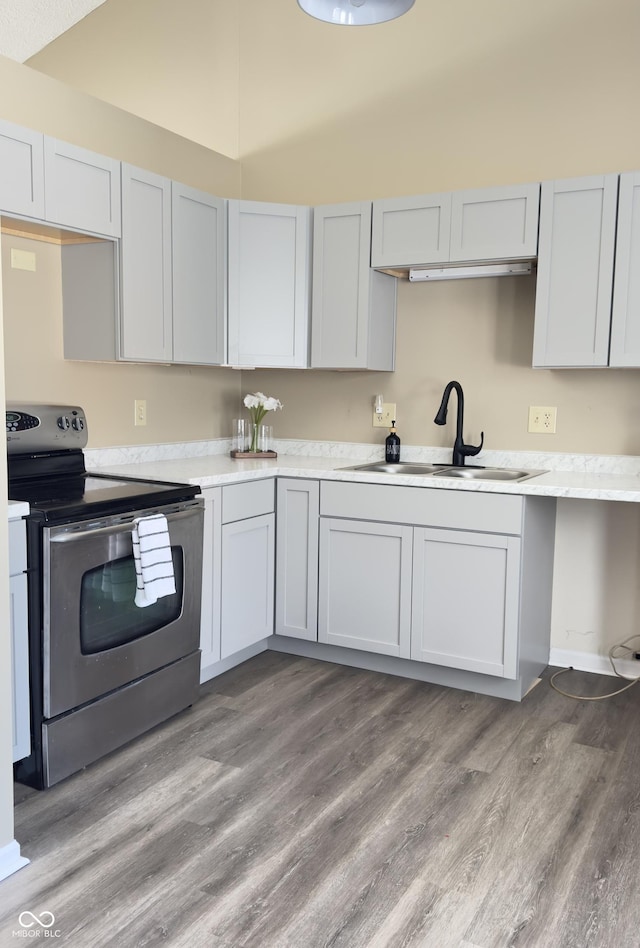 kitchen featuring a sink, white cabinets, light wood-style floors, light countertops, and stainless steel electric range