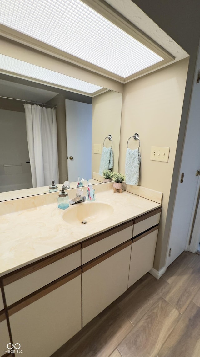 full bath featuring vanity and wood finished floors