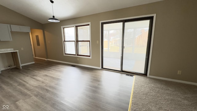 unfurnished living room with visible vents, baseboards, and vaulted ceiling