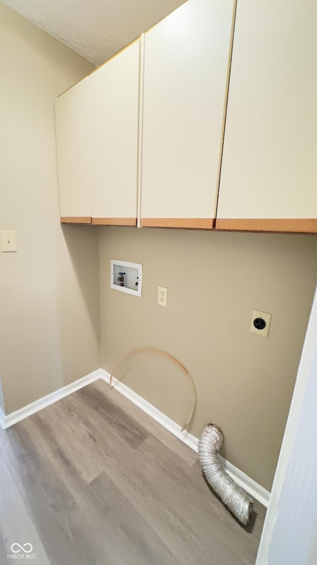 washroom with washer hookup, light wood finished floors, cabinet space, electric dryer hookup, and baseboards