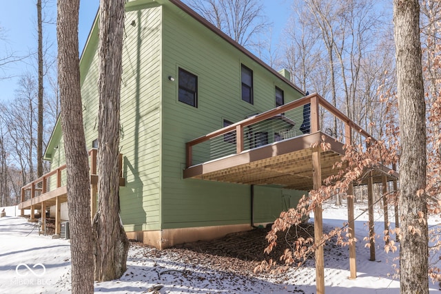 view of snowy exterior with a wooden deck