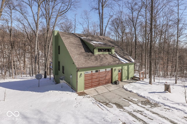 exterior space featuring roof with shingles and driveway