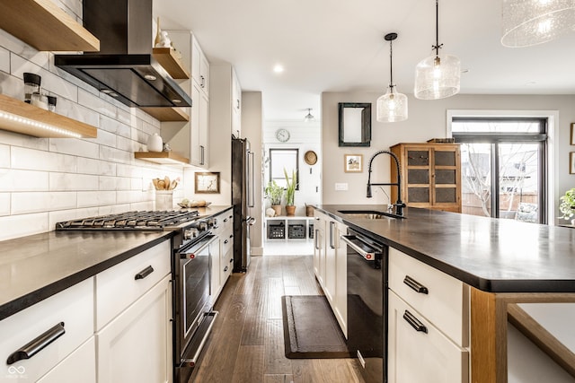 kitchen with high end appliances, dark countertops, a sink, and wall chimney range hood