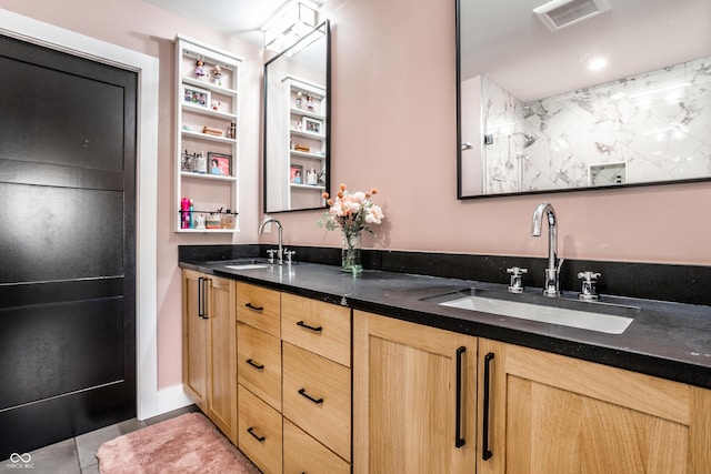 bathroom featuring double vanity, visible vents, a sink, and tile patterned floors