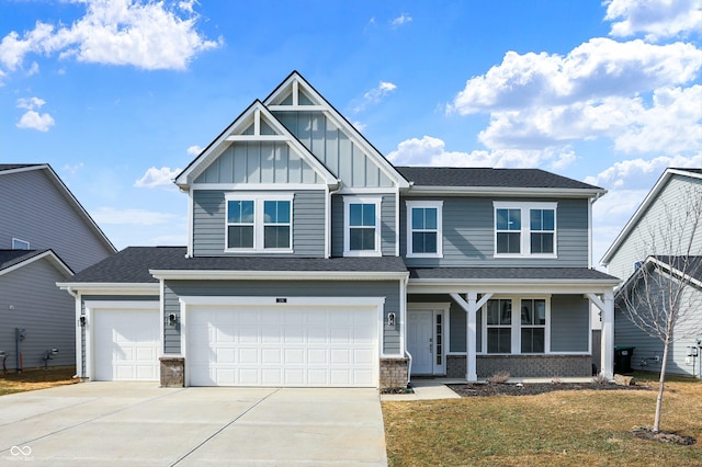 craftsman inspired home with driveway, a shingled roof, an attached garage, board and batten siding, and brick siding