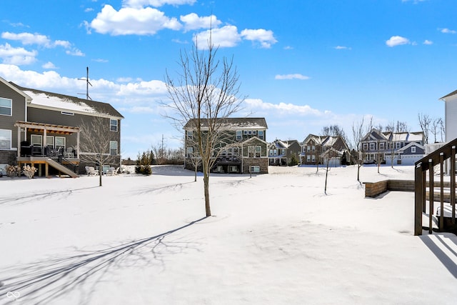 snowy yard with stairs and a residential view