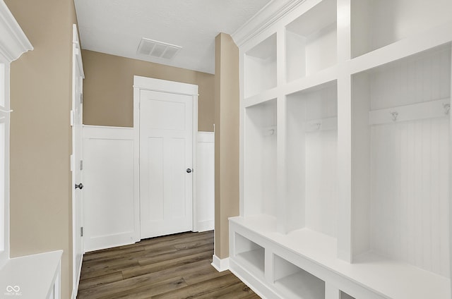 mudroom featuring dark wood-style floors, a textured ceiling, wainscoting, and visible vents