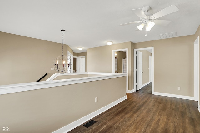 unfurnished room featuring visible vents, baseboards, and dark wood-type flooring