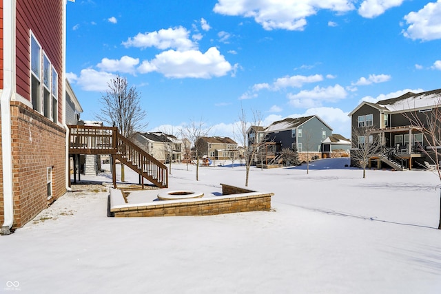 yard layered in snow with stairs and a residential view