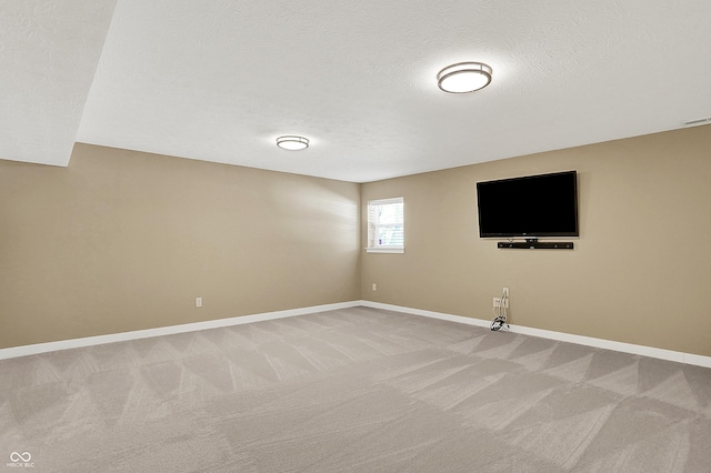 unfurnished room with light carpet, a textured ceiling, visible vents, and baseboards