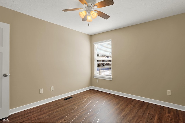 empty room featuring visible vents, baseboards, dark wood finished floors, a ceiling fan, and a textured ceiling