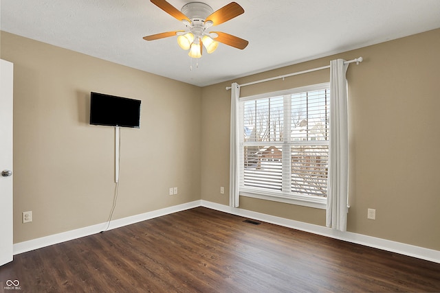 interior space with dark wood-style flooring, visible vents, and baseboards