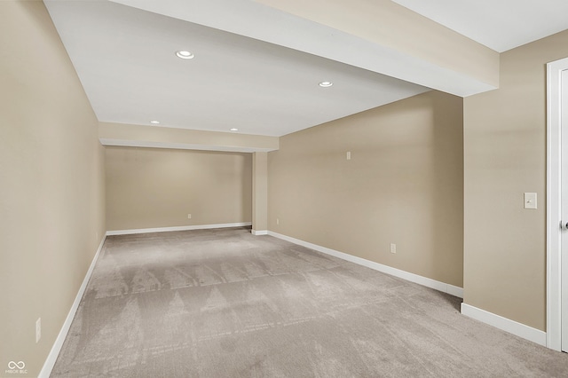 empty room featuring recessed lighting, light carpet, and baseboards