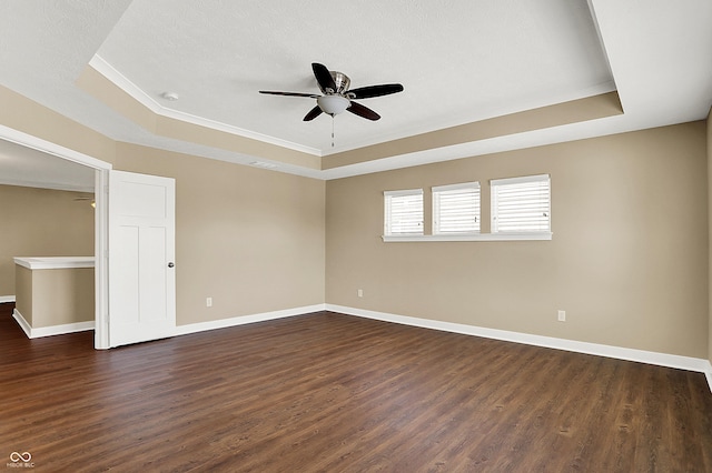 unfurnished room featuring dark wood-style floors and a raised ceiling