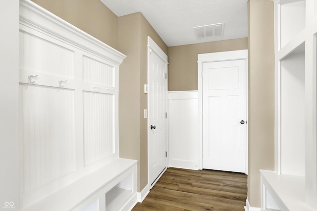 mudroom featuring visible vents, dark wood finished floors, and a textured ceiling