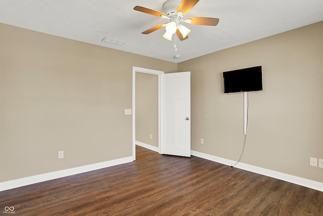 unfurnished bedroom featuring a ceiling fan, dark wood-style flooring, visible vents, and baseboards