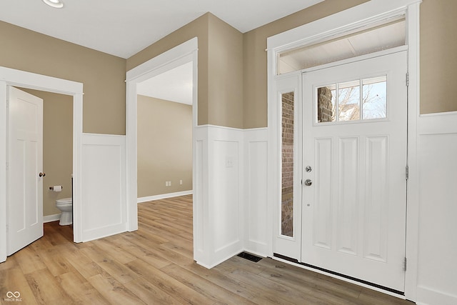 entrance foyer with light wood-type flooring and wainscoting