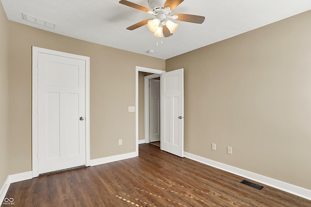 unfurnished bedroom featuring a ceiling fan, wood finished floors, visible vents, and baseboards