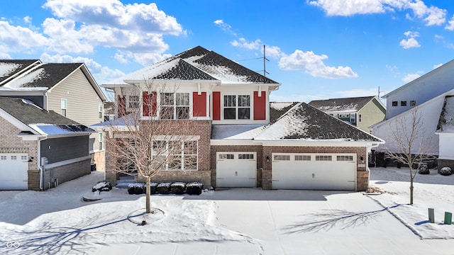 view of front facade with a garage, driveway, and brick siding