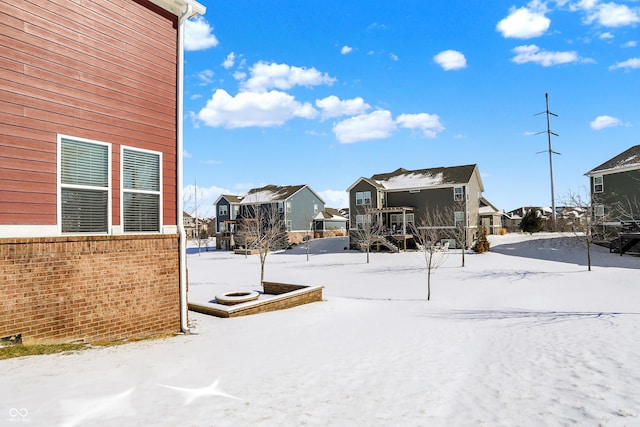 snowy yard featuring a residential view