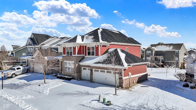 view of front facade featuring a residential view, brick siding, and an attached garage