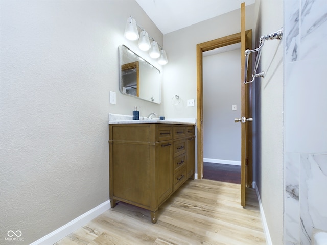 bathroom with vanity, baseboards, and wood finished floors