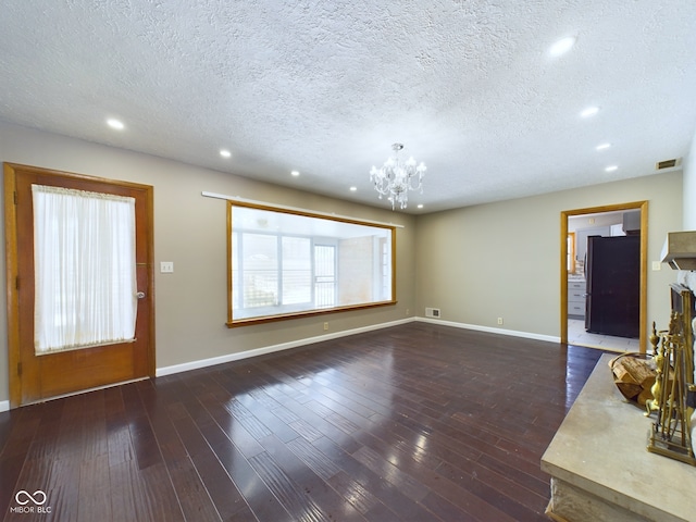 foyer with baseboards, a notable chandelier, visible vents, and wood finished floors