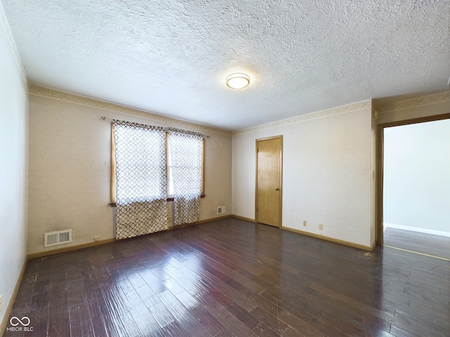 unfurnished room featuring dark wood-type flooring and visible vents