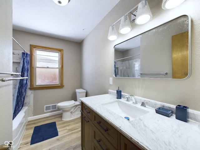 full bath with toilet, wood finished floors, vanity, visible vents, and shower / tub combo with curtain