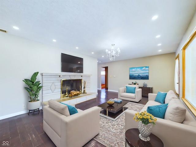 living room with recessed lighting, a fireplace with raised hearth, baseboards, and wood finished floors