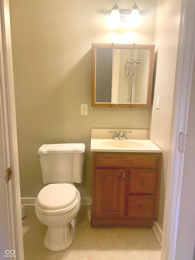 bathroom with toilet, tile patterned flooring, baseboards, and vanity