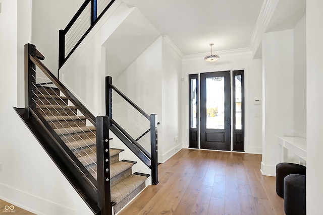 entrance foyer featuring ornamental molding, baseboards, and hardwood / wood-style flooring