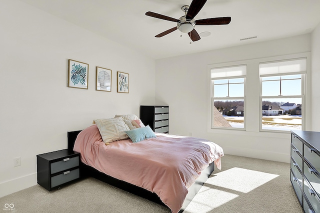 bedroom with baseboards, visible vents, a ceiling fan, and light colored carpet