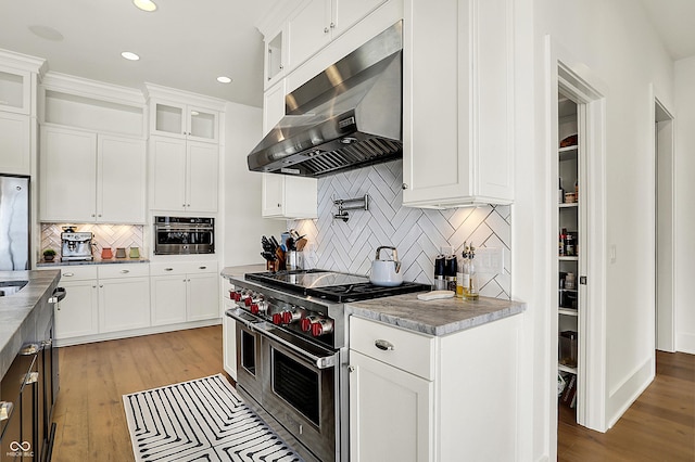 kitchen featuring stainless steel appliances, light wood finished floors, white cabinetry, and under cabinet range hood