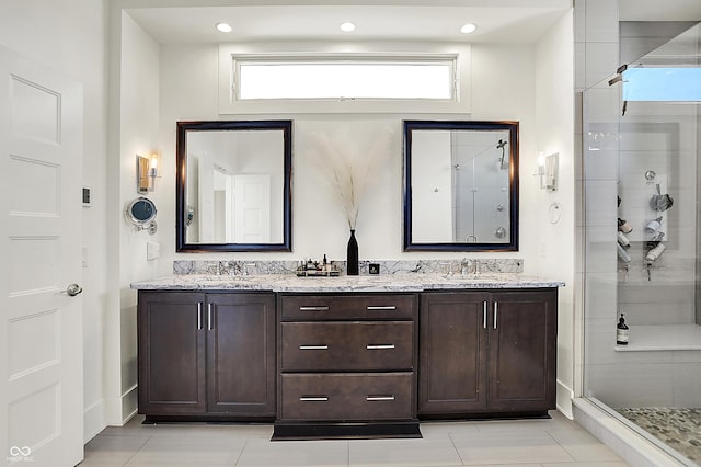 full bathroom with double vanity, a stall shower, and a healthy amount of sunlight