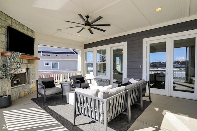 view of patio / terrace with an outdoor living space with a fireplace and a ceiling fan