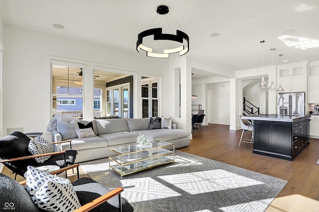 living room with ceiling fan, dark wood finished floors, and stairs