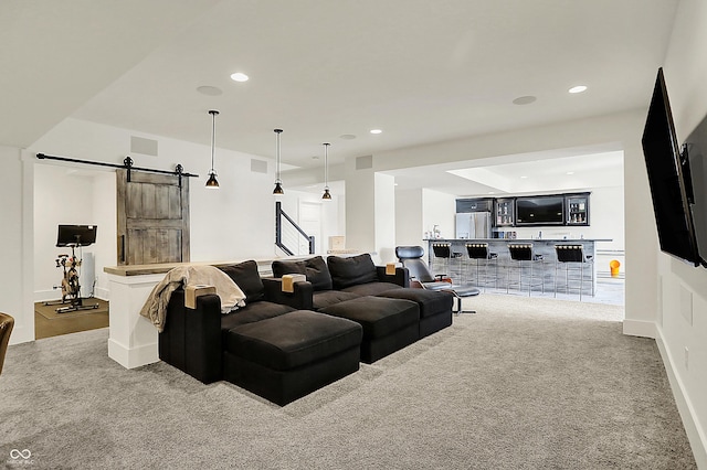 living area featuring recessed lighting, visible vents, carpet flooring, and a barn door