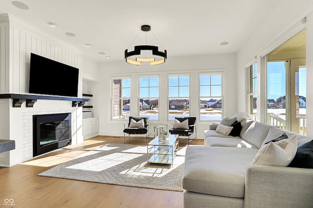 living room with a glass covered fireplace and wood finished floors