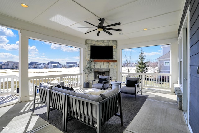 interior space with ceiling fan, an outdoor living space with a fireplace, and a residential view